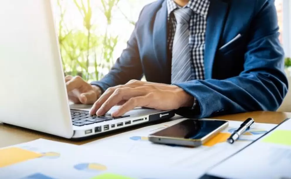 hombre-de-negocios-que-trabaja-en-la-oficina-con-la-computadora-portatil-la-tableta-y-los-documentos-de-datos-del-grafico-en-su-escritorio_1423-107