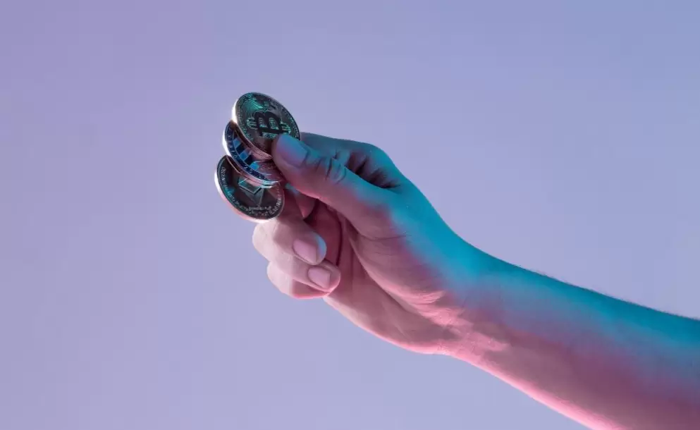 male-hand-with-golden-bitcoin-on-blue-background