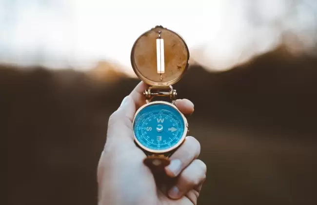 closeup-shot-of-person-holding-compass-with-burred-background