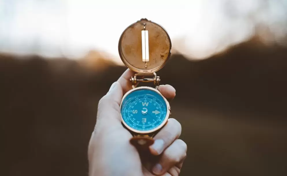 closeup-shot-of-person-holding-compass-with-burred-background