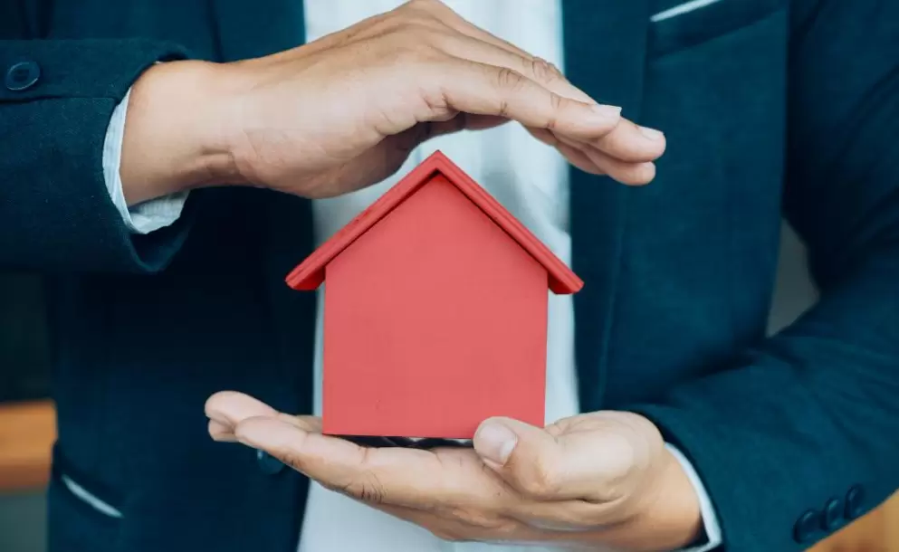 business-man-hand-hold-the-house-model-saving-small-house