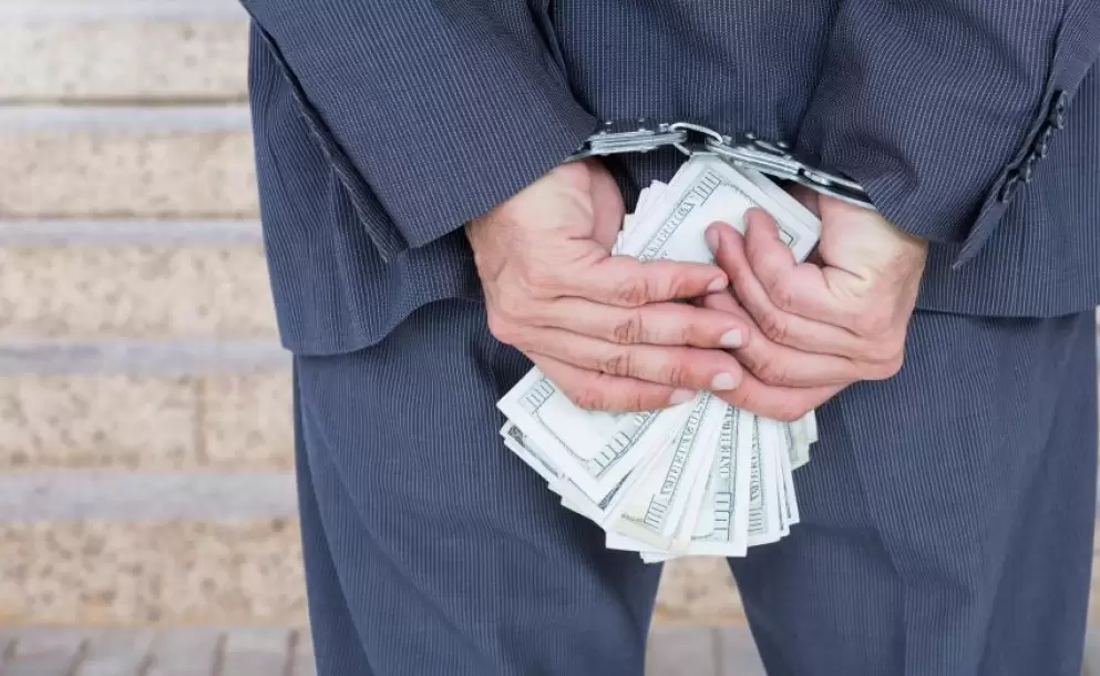 businessman-hands-in-handcuffs-holding-us-dollars