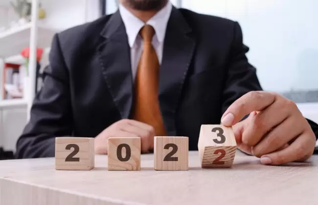 hand-of-businessman-holding-wooden-cube-with-number-2023-business-idea-new-year-concept