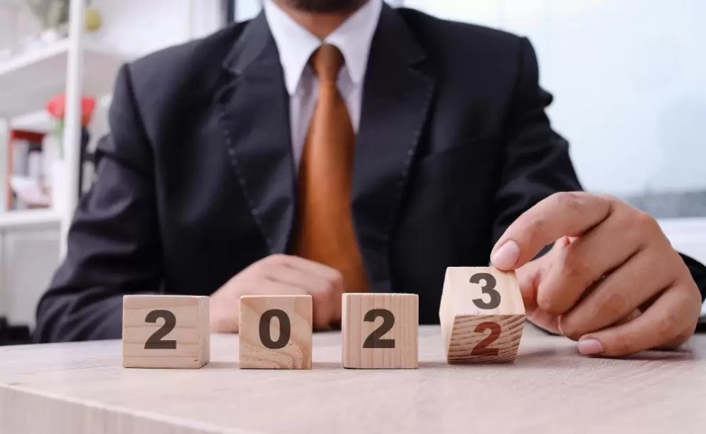 hand-of-businessman-holding-wooden-cube-with-number-2023-business-idea-new-year-concept