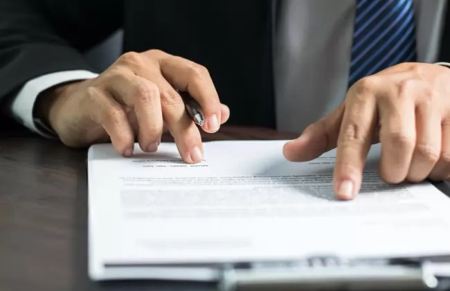 businessman-or-lawyer-reading-and-signing-on-contract-paper