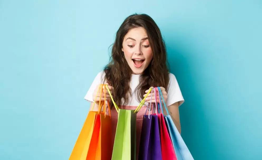 imagen-mujer-joven-feliz-monton-bolsas-compra-comprando-cosas-descuentos-primavera-pie-sobre-fondo-azul